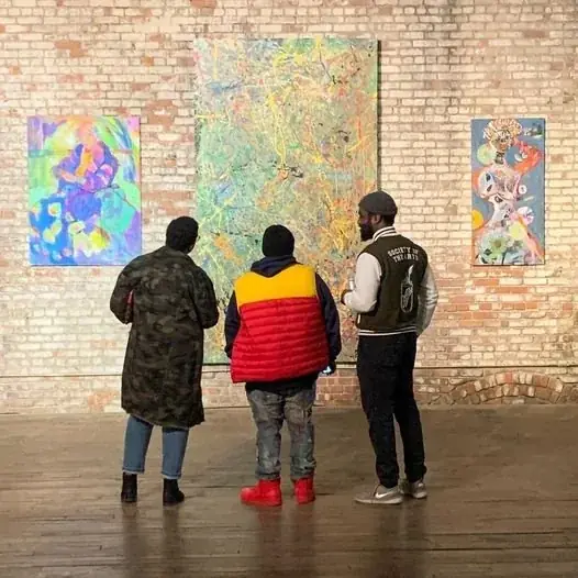 Visitors viewing artwork in GARNER’s brick-walled gallery